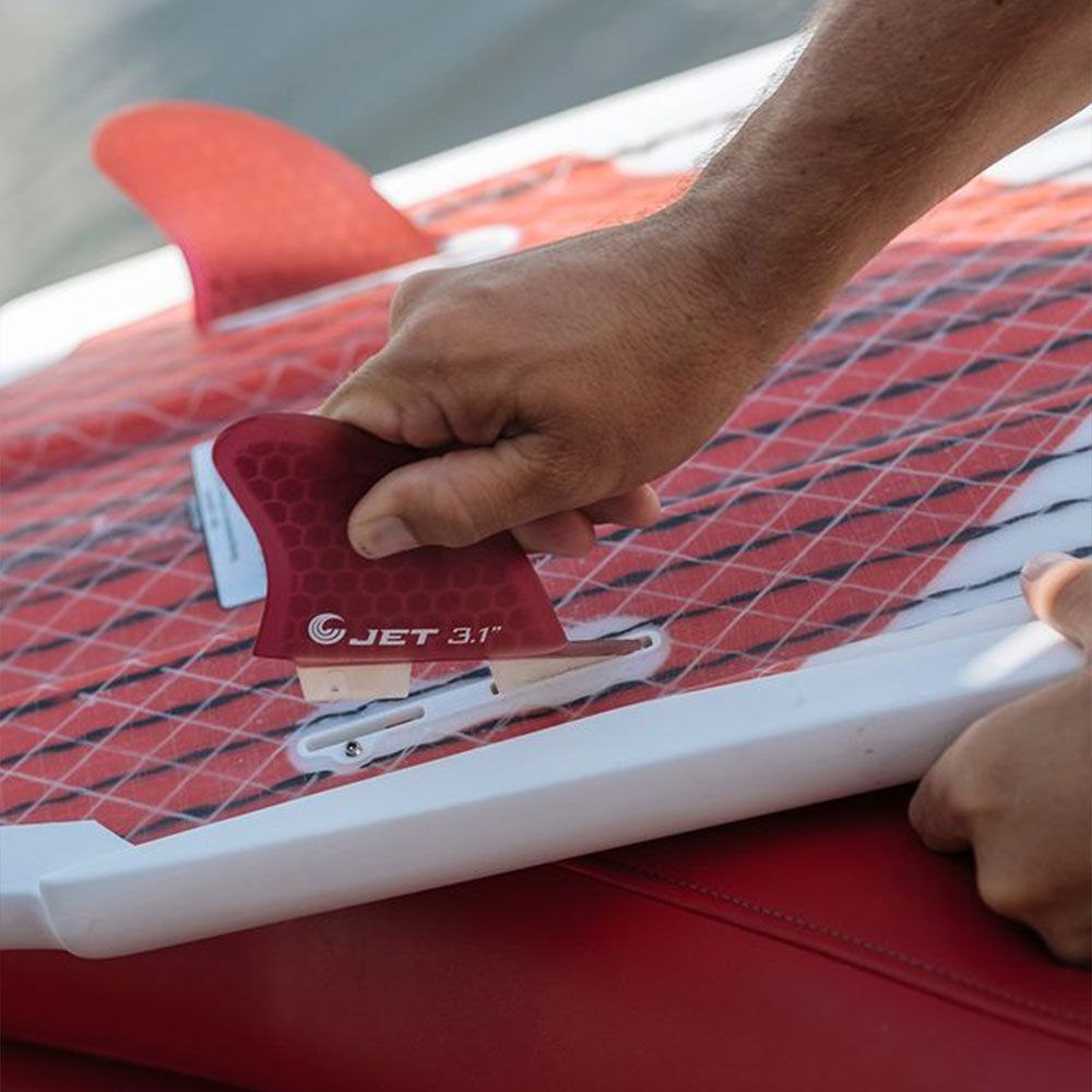 hand putting fin onto wake board