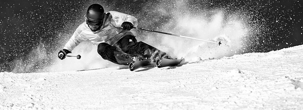 Skier carving through snow