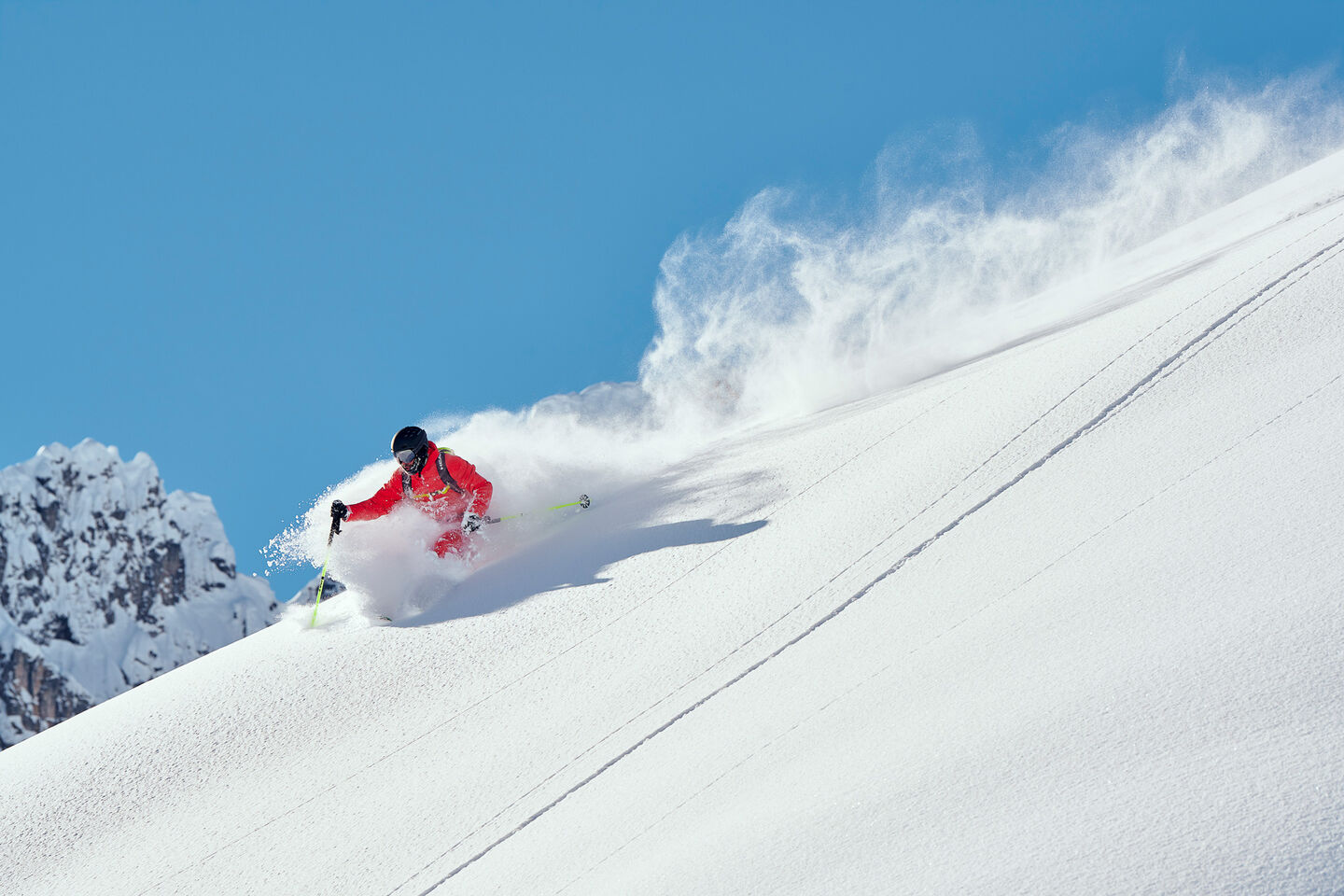 Man on HEAD skis in fresh powder with blue sky