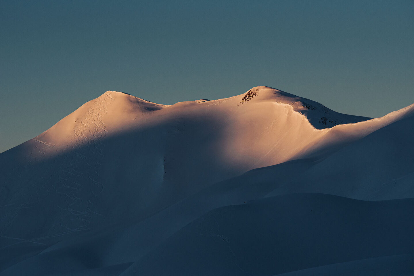 Mountain peaks with ski tracks through freshly fallen snow