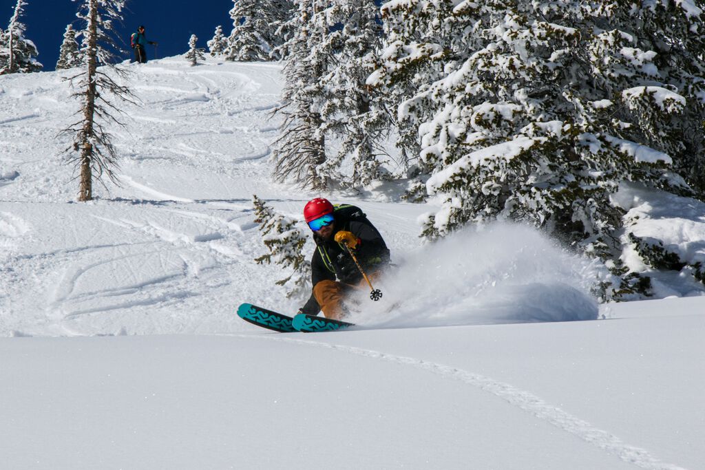 Man making a turn in powder on skis