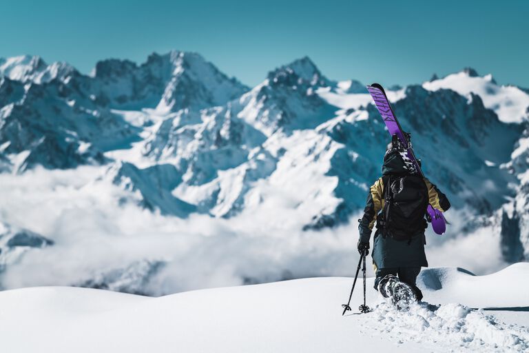 skier walking with skis on their sholder