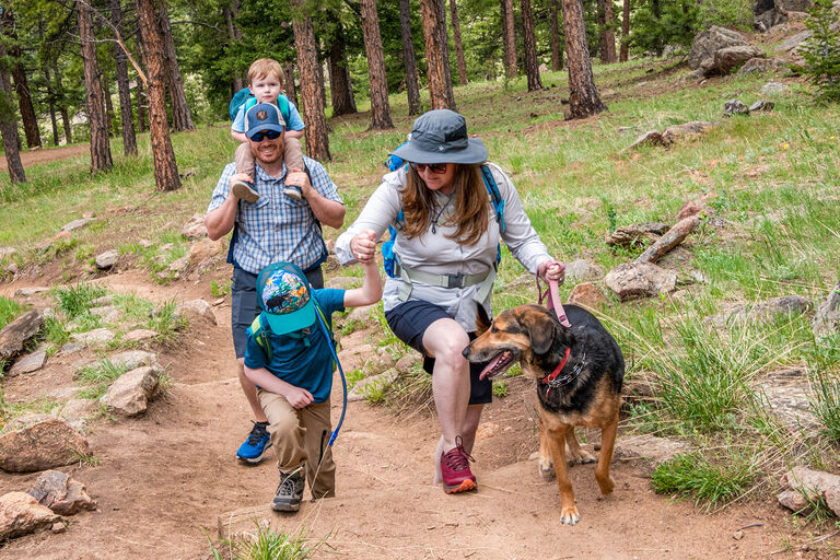 Family of four hiking with their dog