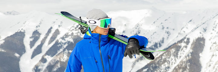 Man holding skis over shoulder