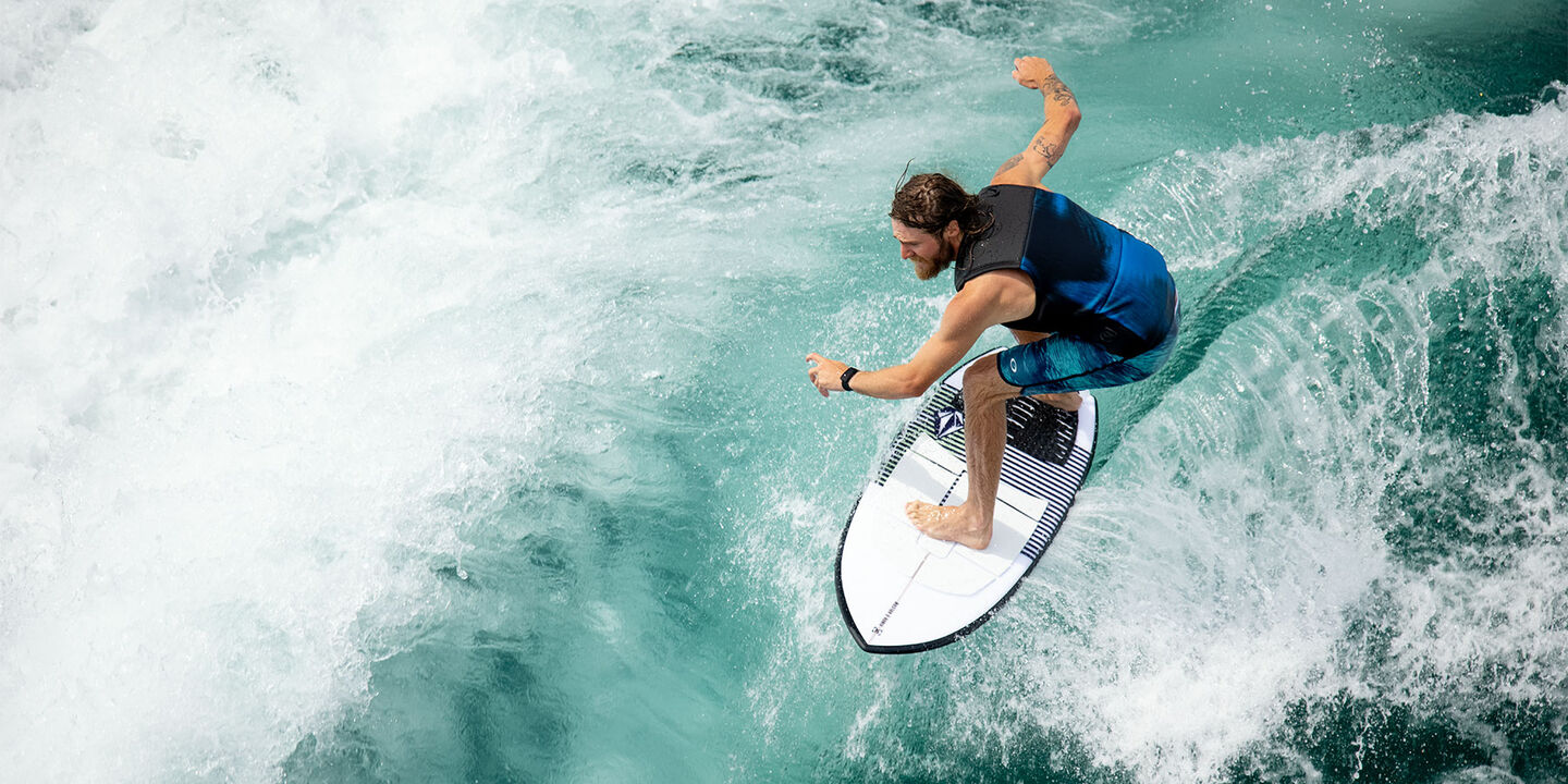 Man on a wakesurf board riding wave