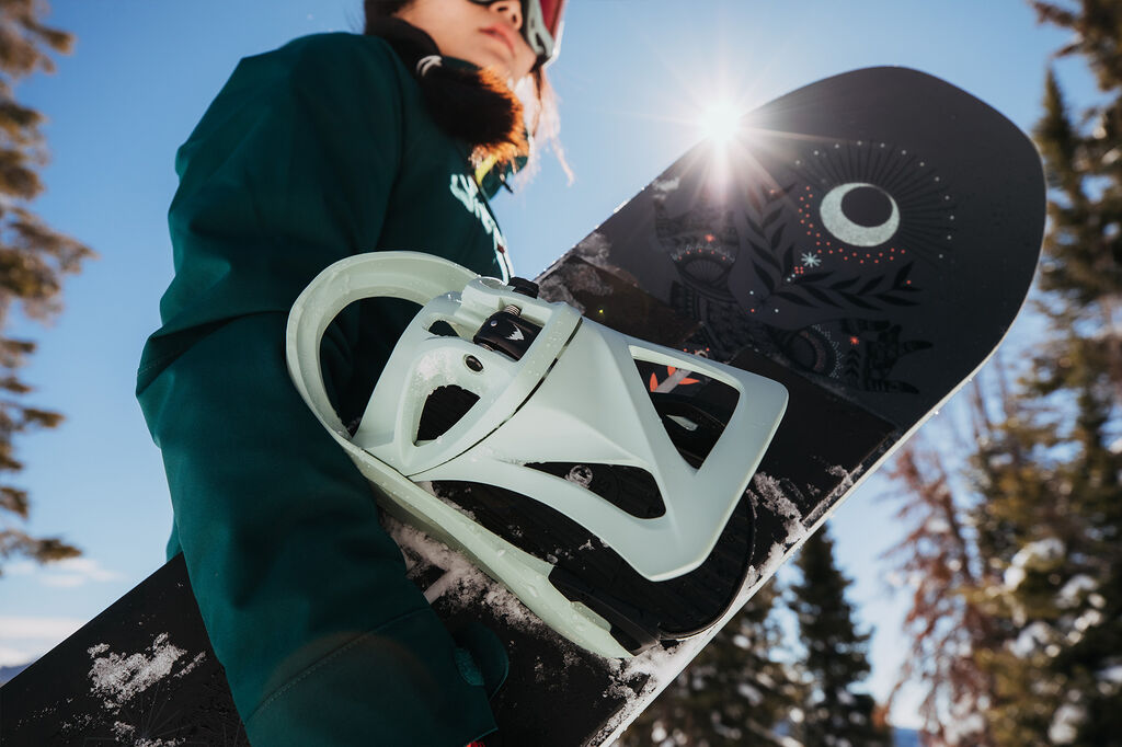 woman holding snowboard with binding